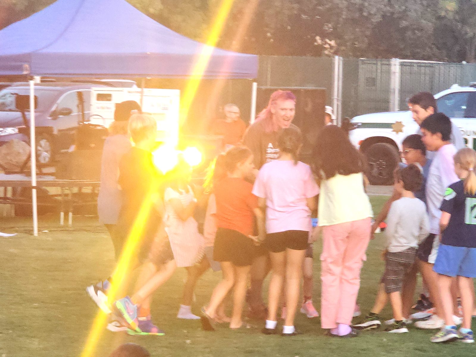 Jared Hippler leading a big circle of laughing kids in a play game